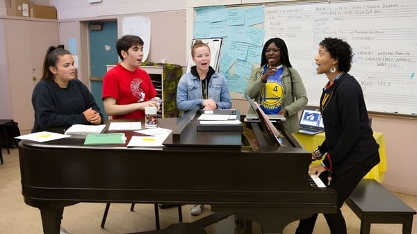 Schüler der H.B. Beal Secondary School spielen gemeinsam Klavier in einem Klassenraum.