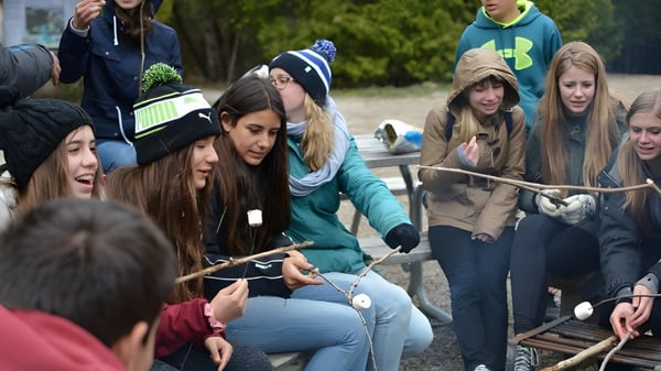 Eine Gruppe von Schülerinnen und Schülern der Hamelin-Laie International School versammelt sich im Freien zu einer sozialen Aktivität.