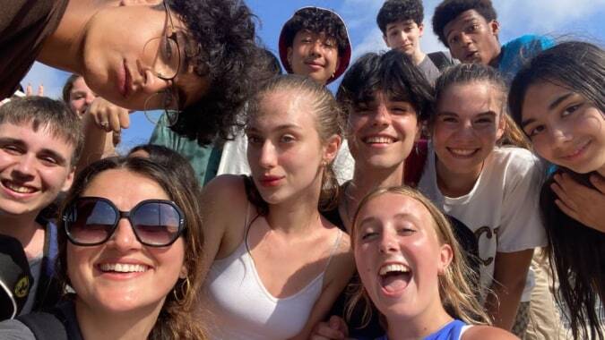 Eine Gruppe lächelnder Schülerinnen und Schüler der Hamelin-Laie International School versammelt sich im Freien unter blauem Himmel.