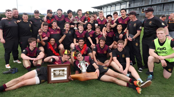 Eine Gruppe Schüler der Hamilton Boy's High School posiert auf dem Sportfeld und hält einen Pokal nach einem Sieg.