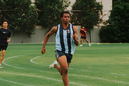 Eine Schülerin oder ein Schüler des Hamilton Secondary College läuft auf einem grünen Feld während einer sportlichen Aktivität.