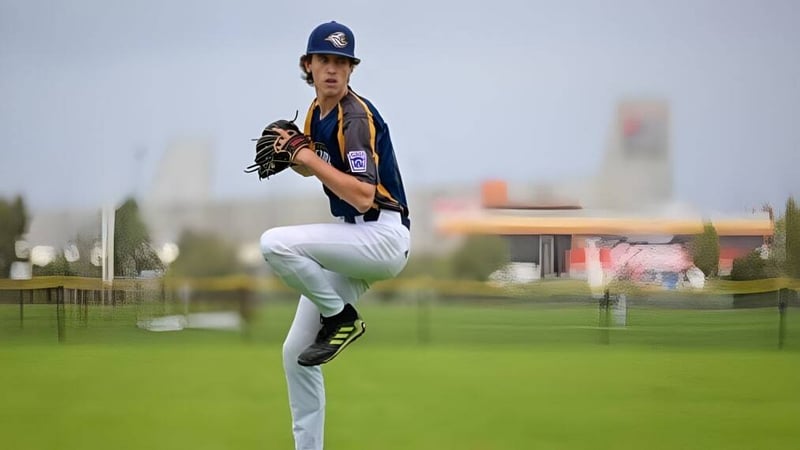 Ein Baseballspieler steht auf dem Spielfeld der Hampton Senior High School vor einer Stadtkulisse.