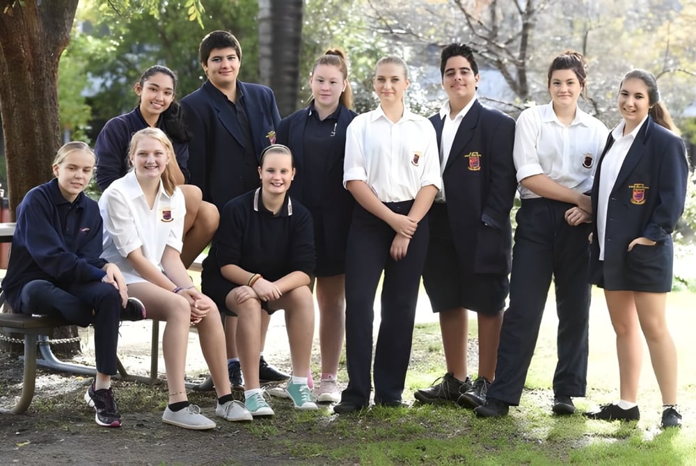 Eine Gruppe von Schülerinnen und Schülern steht und sitzt gemeinsam in einem natürlichen Außenbereich der Hampton Senior High School.
