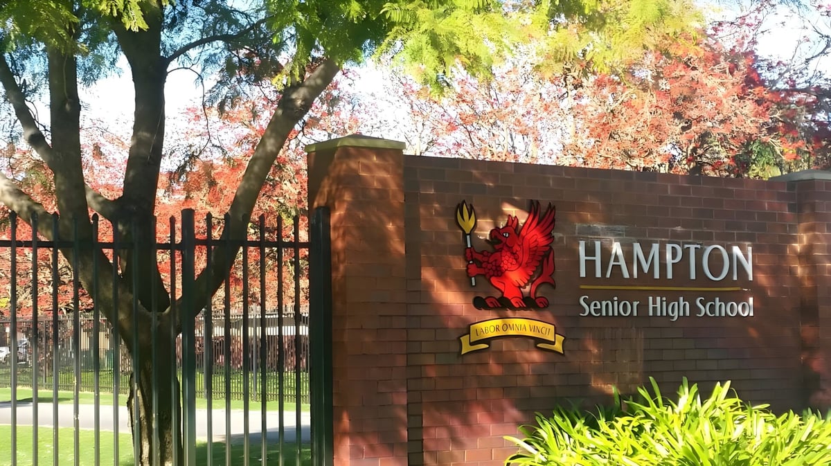 Das Ziegelschild von Hampton Senior High School steht vor bunten Bäumen.