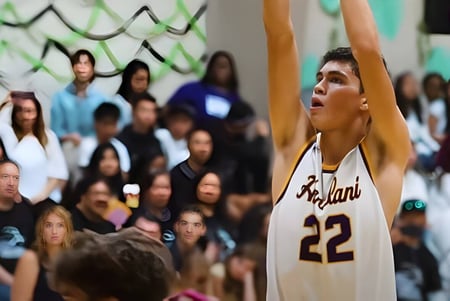 Ein Basketballspieler in einem weißen Trikot mit der Nummer 22 springt in der Turnhalle der Hanalani Schools.