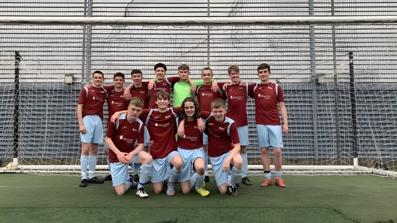 Eine Gruppe von Schülerinnen und Schülern der Hanham Woods Academy posiert gemeinsam auf dem Fußballfeld.
