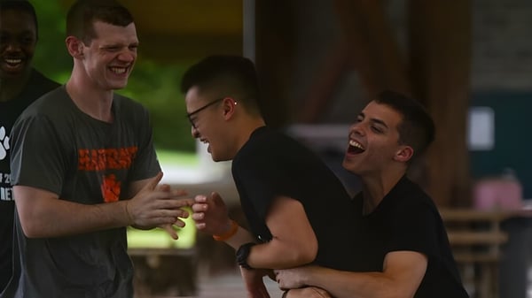 Drei Männer führen eine lebhafte Unterhaltung auf dem Gelände der Hargrave Military Academy.