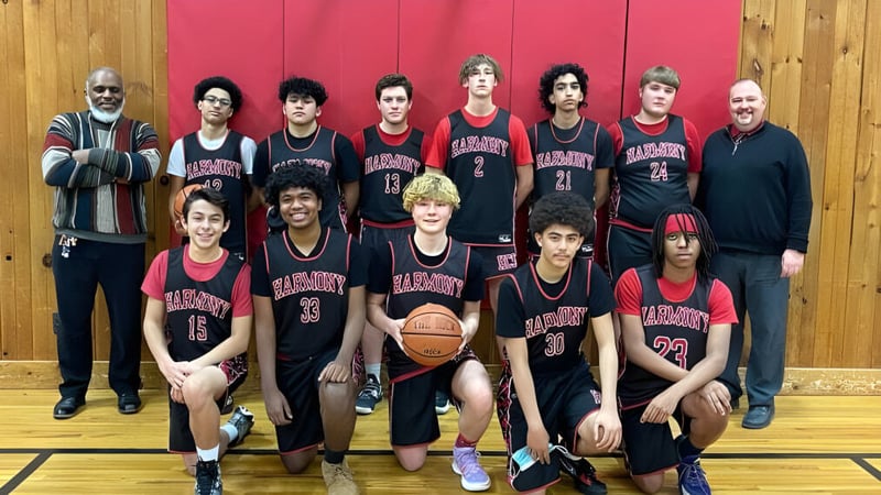 Eine Gruppe von Schülerinnen und Schülern der Harmony Christian School posiert gemeinsam in der Sporthalle beim Basketball.