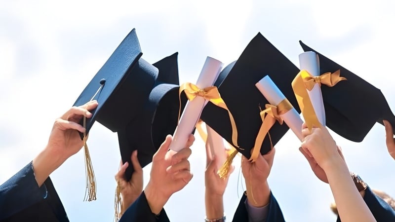 Schüler der Harry Ainlay High School halten ihre Absolventenhüte in die Luft zur Feier des Schulabschlusses.