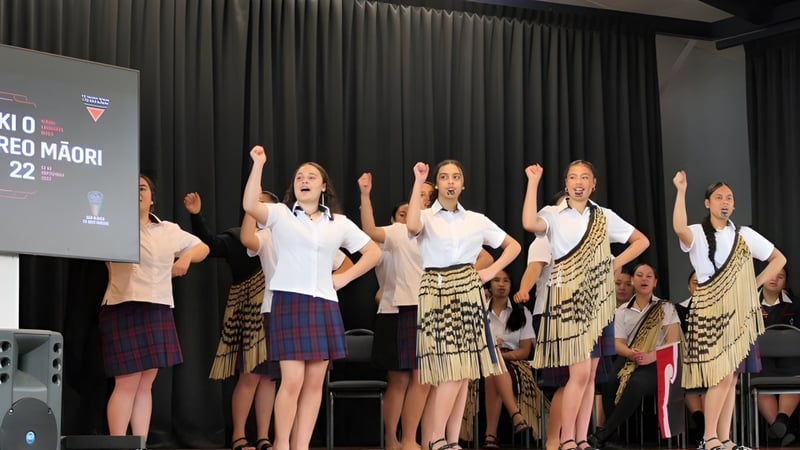 Schülerinnen der Hastings Girls' High School führen in traditioneller Māori-Kleidung einen Tanz auf einer Bühne auf.