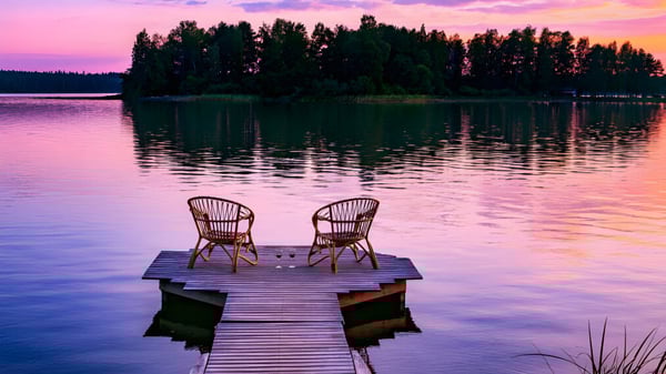 Ein Steg mit zwei Korbstühlen an einem See auf dem Campus des Havergal College bei Sonnenuntergang.