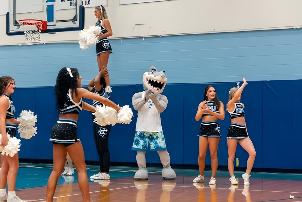 Cheerleader in bunten Uniformen treten auf dem Basketballfeld der Hawai'i Pacific University auf.