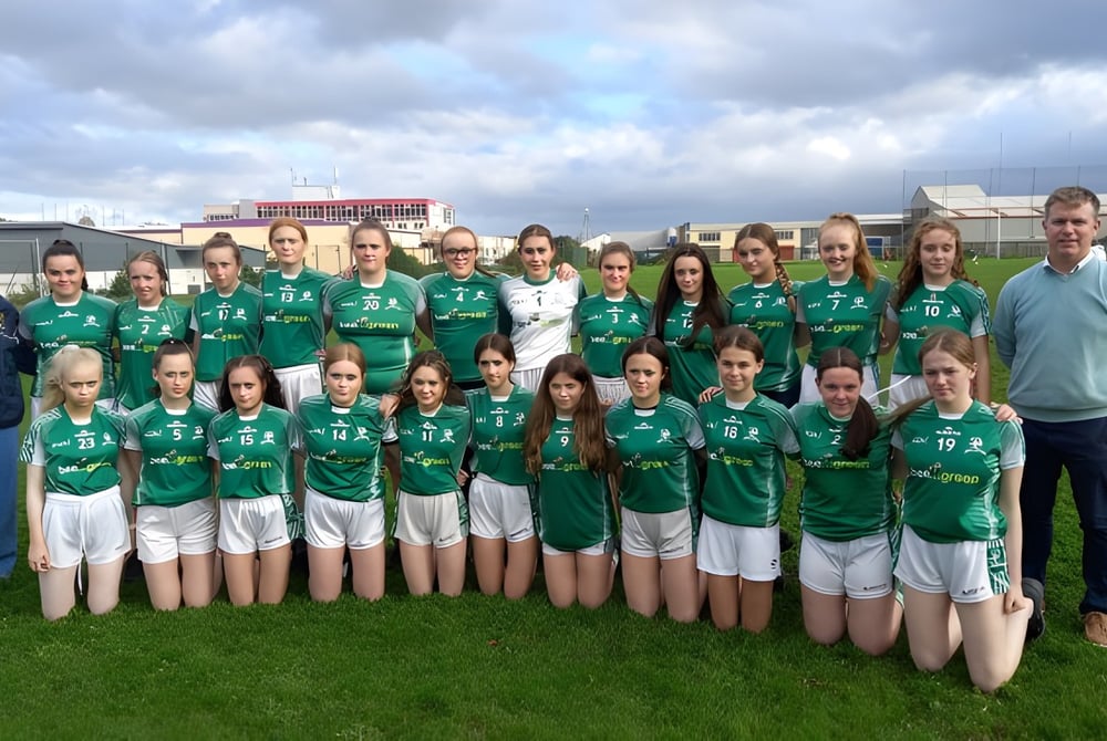 Eine Gruppe von jungen Athletinnen im grünen Trikot posiert gemeinsam auf einem Feld auf dem Campus des Hazelwood College.