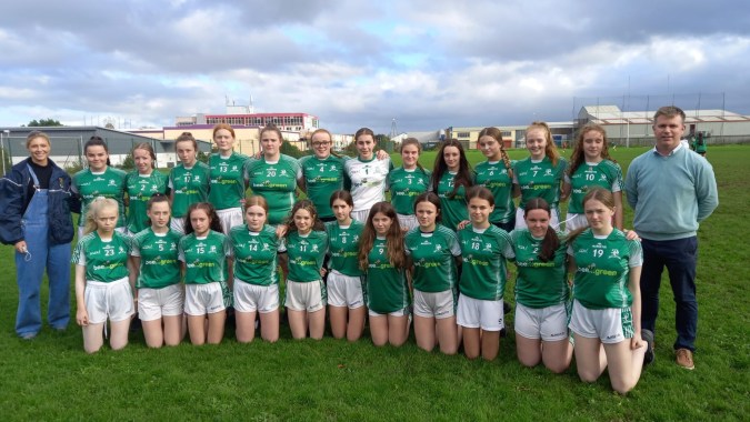 Eine Gruppe junger Fußballspielerinnen in grünen Trikots auf dem Spielfeld des Hazelwood College.
