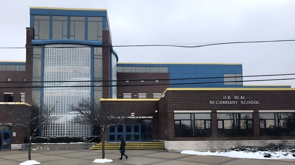 Das moderne mehrstöckige Schulgebäude der H.B. Beal Secondary School mit Glasfassade steht im verschneiten Gelände.