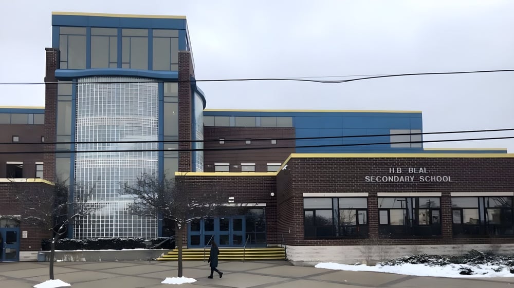 Das moderne mehrstöckige Schulgebäude der H.B. Beal Secondary School mit Glasfassade steht im verschneiten Gelände.