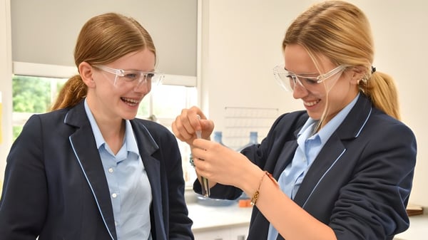 Zwei Schülerinnen der Headington School führen ein Gespräch in einem professionellen Bürobereich.