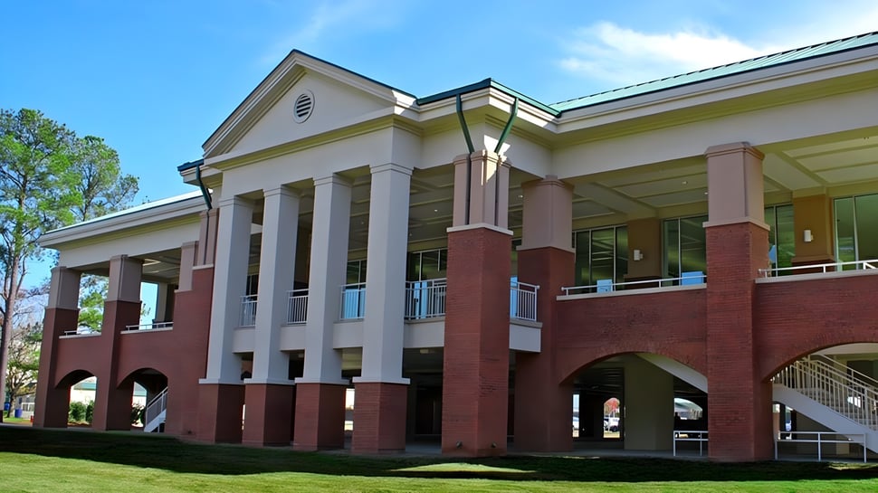 Das mehrstöckige Backsteingebäude mit Säuleneingang und grünem Dach steht auf dem Gelände der Heathwood Hall Episcopal School.