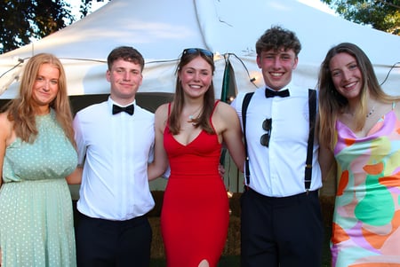 Eine Gruppe von fünf Schülern der Hereford Cathedral School steht vor einem Zelt im Freien mit Bäumen im Hintergrund.