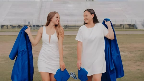 Zwei Schülerinnen der Heritage High School stehen gemeinsam draußen vor einer großen Arena und lächeln.