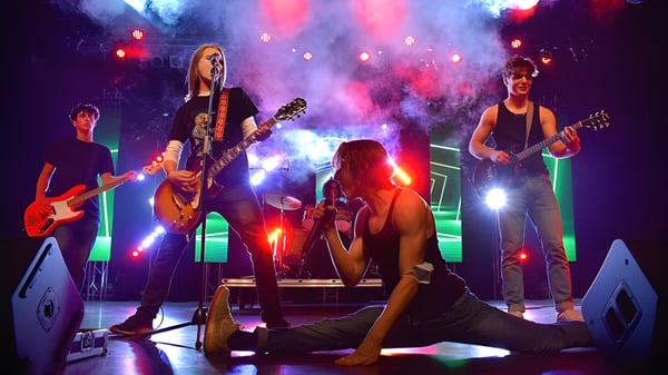 Schüler der Heritage Regional High School spielen als lebendige Rockband mit dynamischer Bühnenbeleuchtung und Rauch.