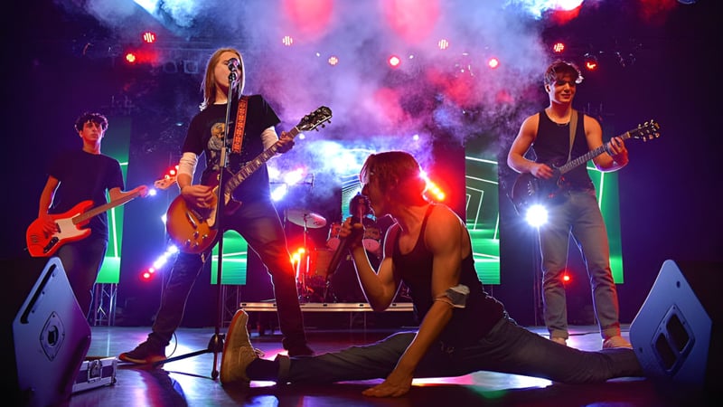 Schüler der Heritage Regional High School spielen als lebendige Rockband mit dynamischer Bühnenbeleuchtung und Rauch.