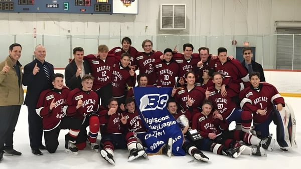 Eine Gruppe von Schülerinnen und Schülern der Heritage Woods Secondary School posiert gemeinsam in einer Eishockeyhalle mit Trikots und Ausrüstung.