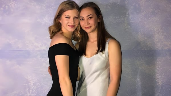 Zwei Schülerinnen der Heritage Woods Secondary School posieren vor hellem Hintergrund.