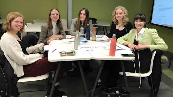 Eine Gruppe Schülerinnen arbeitet gemeinsam an einem Tisch auf dem Campus der Highworth Grammar School.