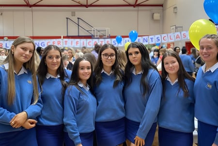 Eine Gruppe von Schülerinnen in blauen Uniformen steht zusammen bei einer Veranstaltung der Highworth Grammar School.