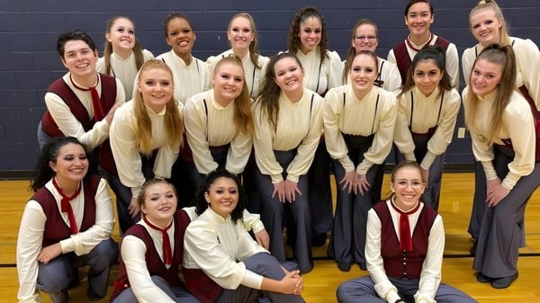 Eine Gruppe Schülerinnen der Higley High School posiert im Gymnasium in einheitlichen Cheerleader-Uniformen.