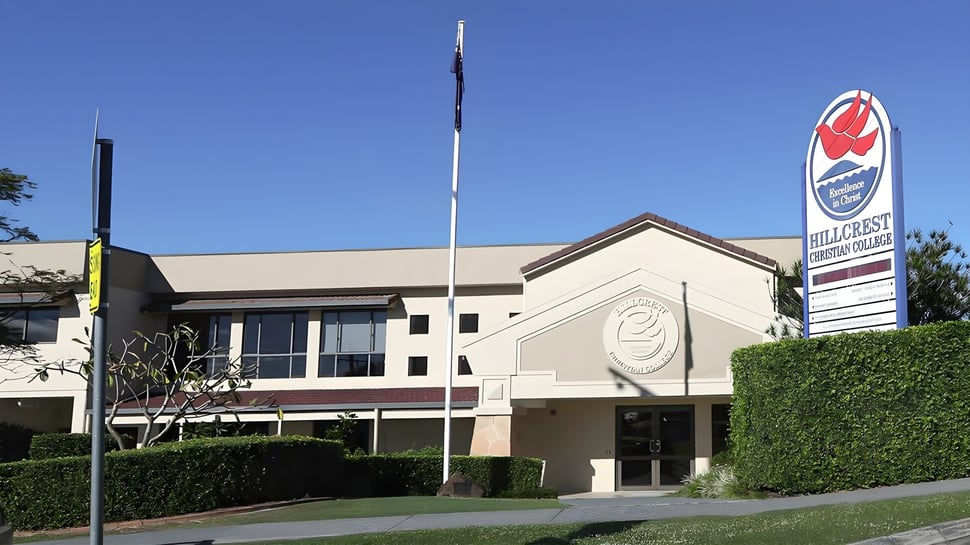 Das moderne mehrstöckige Gebäude von Hillcrest Christian College steht in einer gepflegten Umgebung bei klarem Himmel.