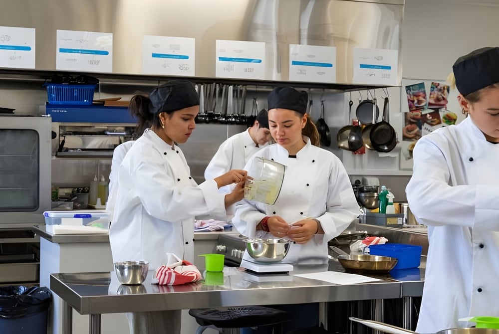 Schüler der Hillmorton High School arbeiten in der Schulküche gemeinsam an der Zubereitung von Speisen.