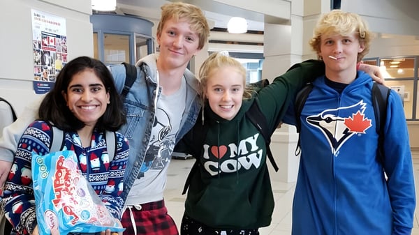 Eine Gruppe von vier Schülerinnen und Schülern steht gemeinsam in der Schule der H.J. Cambie Secondary School.