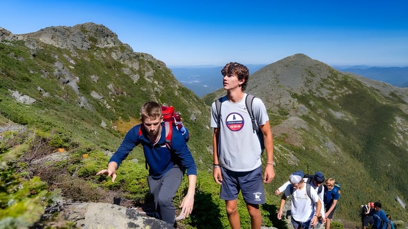 Eine Gruppe von Schülerinnen und Schülern der Holderness School wandert auf einem Bergpfad mit klar blauem Himmel.