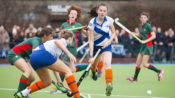 Schülerinnen der Holy Child Secondary School spielen ein intensives Feldhockeyspiel auf dem Sportplatz.