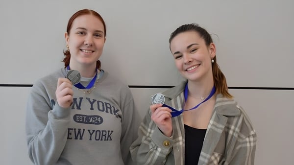 Zwei Personen mit Stethoskopen stehen in einem Raum auf dem Campus der Holy Cross Catholic Secondary School.
