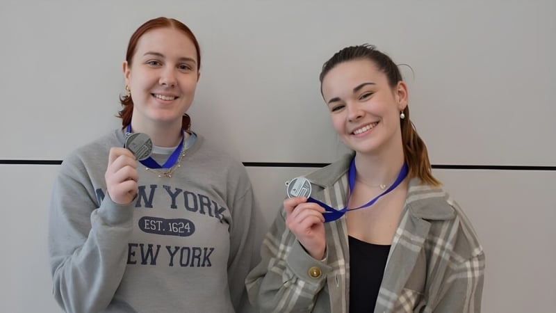 Zwei Personen mit Stethoskopen stehen in einem Raum auf dem Campus der Holy Cross Catholic Secondary School.