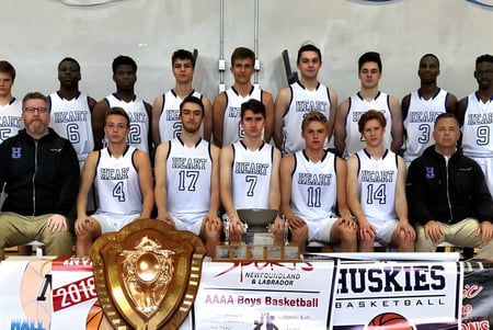 Die Basketballmannschaft der Holy Heart of Mary High School posiert mit einer Trophäe vor dem Basketballfeld.