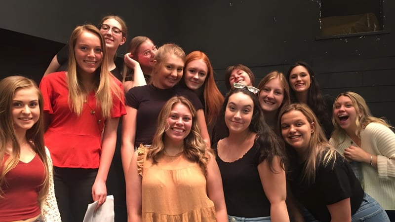 Eine Gruppe Schülerinnen der Holy Heart of Mary High School posiert in einem dunklen Raum.