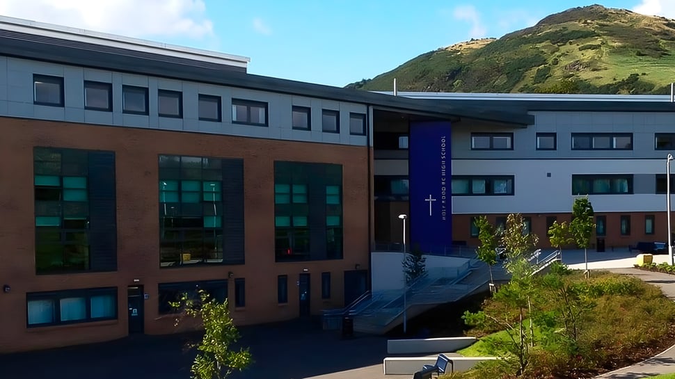 Das mehrstöckige moderne Gebäude der Holy Rood High School ist von üppiger Vegetation umgeben.