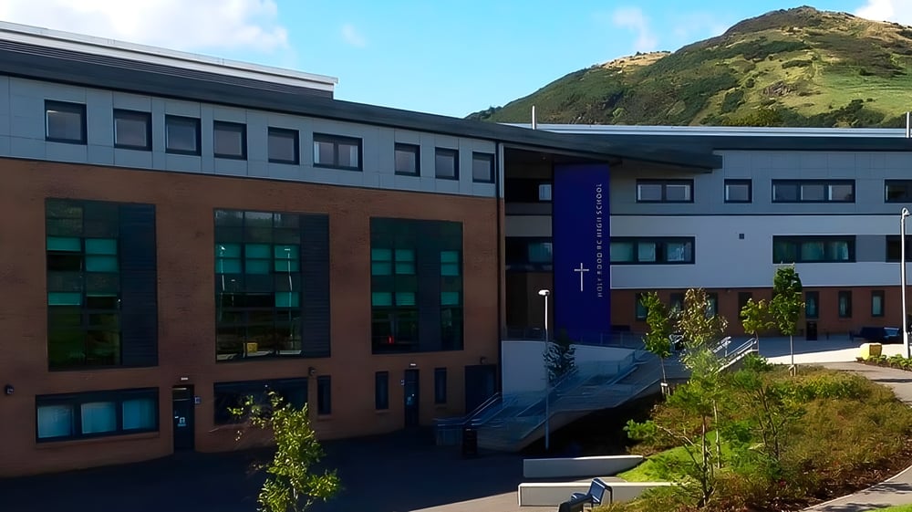 Das mehrstöckige moderne Gebäude der Holy Rood High School ist von üppiger Vegetation umgeben.