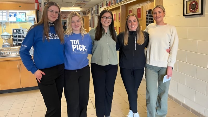 Fünf Schülerinnen stehen zusammen im Flur der Holy Spirit High School mit Spinden im Hintergrund.