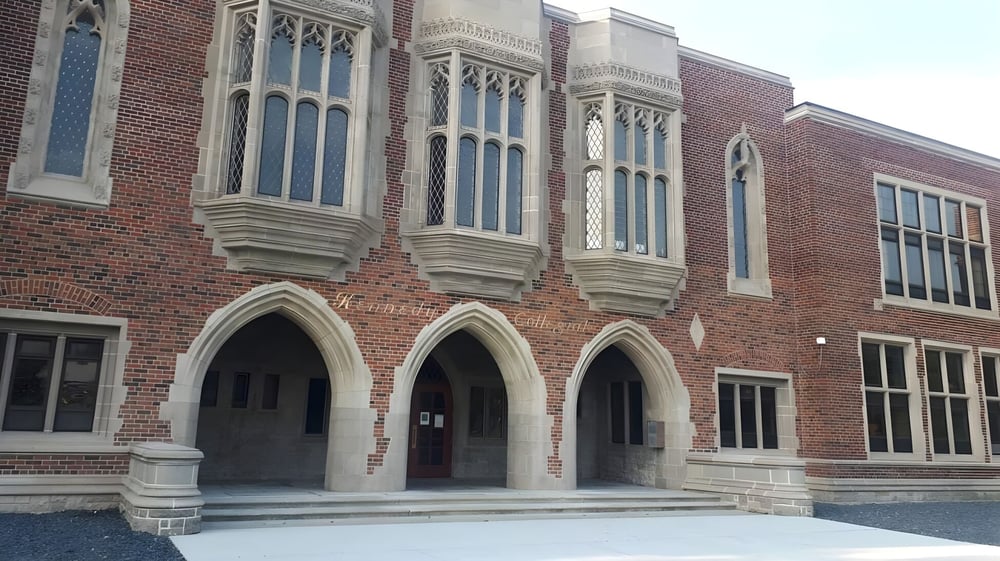 Das Gebäude der Honourable W.C. Kennedy Collegiate zeigt gotische Architektur mit verzierten Steinmetzarbeiten und einem Treppenaufgang am Eingang.