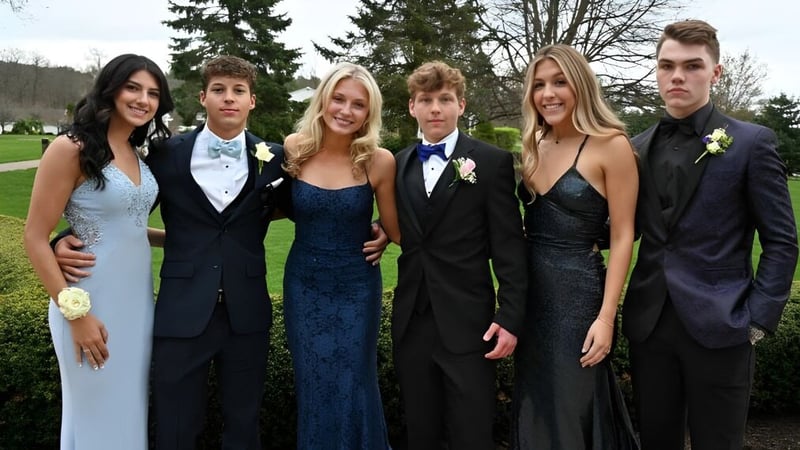 Eine Gruppe Schülerinnen und Schüler des Honourable W.C. Kennedy Collegiate posiert gemeinsam in einem parkähnlichen Außenbereich mit Bäumen.