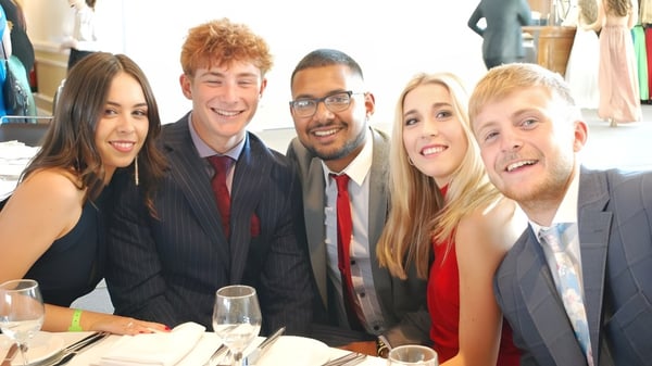 Fünf Personen in formeller Kleidung posieren gemeinsam auf einem Gruppenfoto an der Howard of Effingham School.