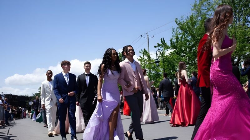 Schüler der Howard S. Billings High School in formeller Kleidung beim Gang auf einem von Grün umgebenen Weg.