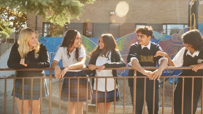 Eine Gruppe Schüler steht vor einem Backsteingebäude auf dem Campus des Hudson College.