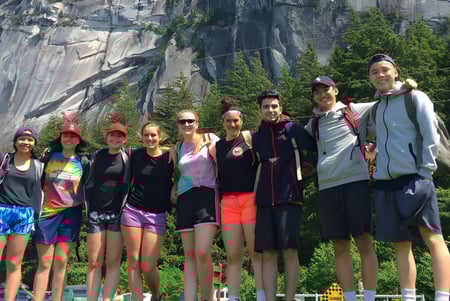Eine Gruppe von Schülerinnen und Schülern der Hugh Boyd Secondary School posiert vor einer felsigen Felsformation im Wald.