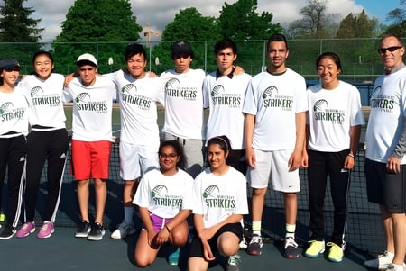 Die Tennismannschaft der Hugh McRoberts Secondary School posiert gemeinsam auf dem Tennisplatz.